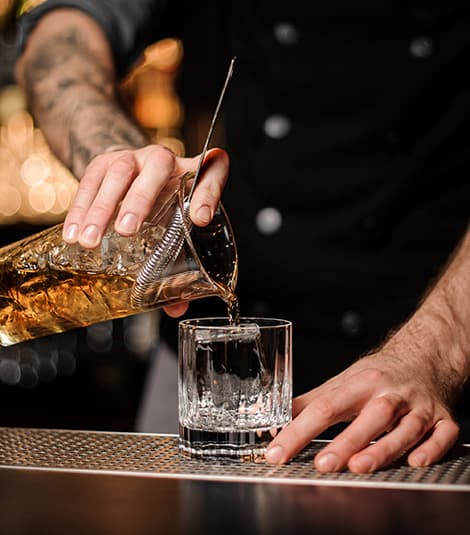 Refined craftsmanship - A bartender pouring premium Land Run Bourbon whiskey from Newkirk, Oklahoma